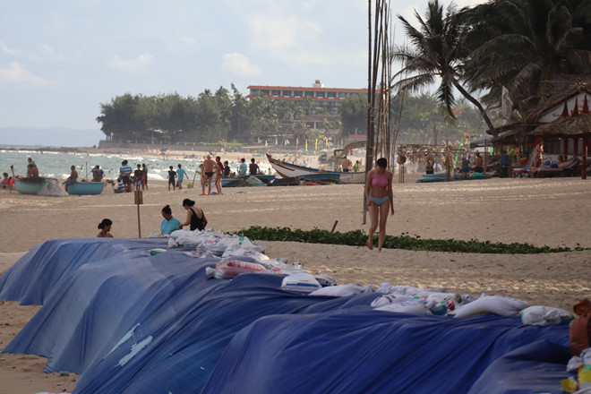 Chưa làm được kè, một resort ở biển Mũi Né dùng bao cát và bạt chống sạt lở bờ biển, trông mất mỹ quan bãi biển vốn đẹp nổi tiếng một thời. QUẾ HÀ