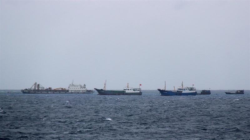 Các tàu cá dân binh Trung Quốc áp tải tàu chở phương tiện xe máy thi công ra bãi Huy Gơ để xây dựng trái phép