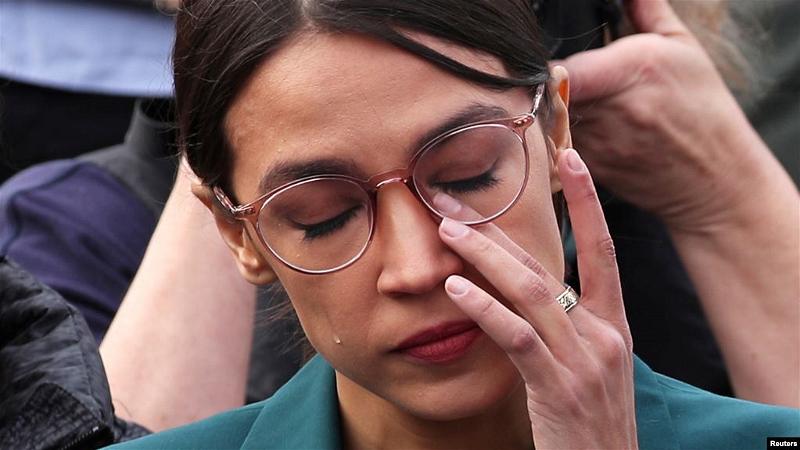 Dân biểu Mỹ Alexandria Ocasio-Cortez (D-NY) gạt nước mắt khi nghe Dân biểu Ilhan Omar (D-MN) kể lại kinh nghiệm trong trại tị nạn tại cuộc họp báo ngày 7/2/2019. REUTERS/Jonathan Ernst